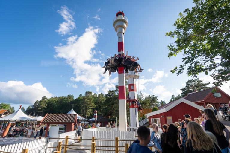 Det er fint vær, og området ved båtbasaren er fullt av gjester som står i kø for å oppleve de forskjellige attraksjonene.
